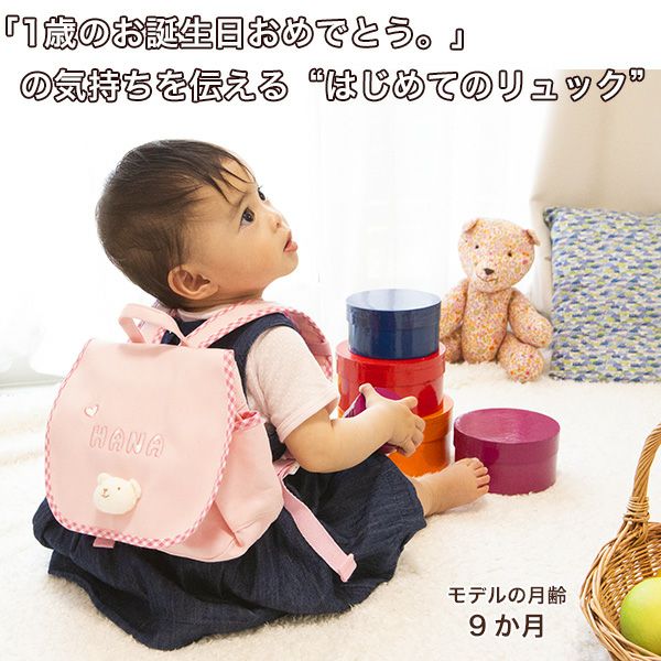 ピンクのくまさんリュックを背負っておもちゃで遊ぶ子ども