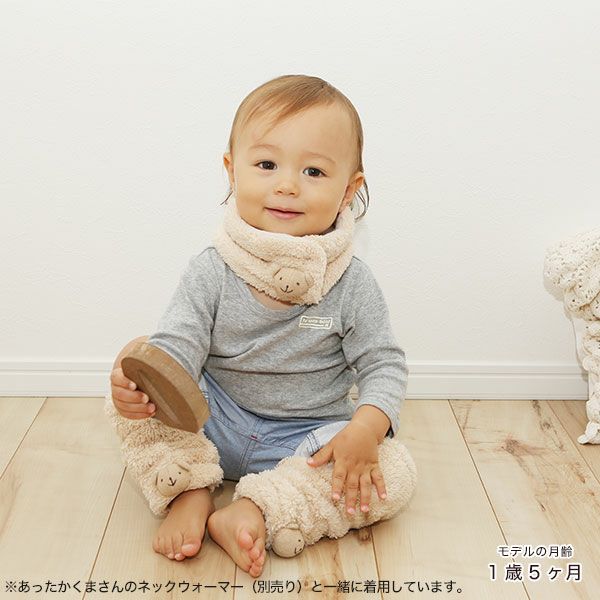 くまさんのレッグウォーマーを着けて床に座る赤ちゃん