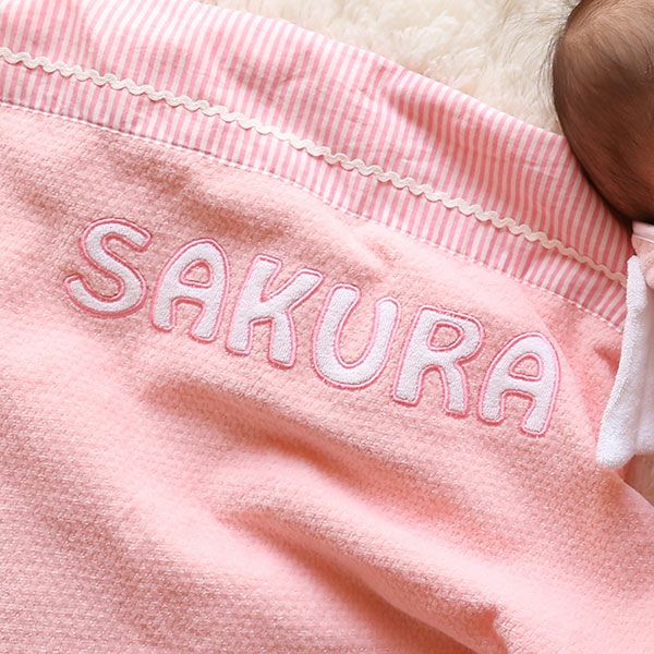 ピンク色のタオルケットに入ったお名前刺繍のディテール