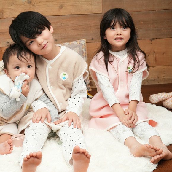 スリーパーを着た赤ちゃんと子どもたちが並んで座っている様子