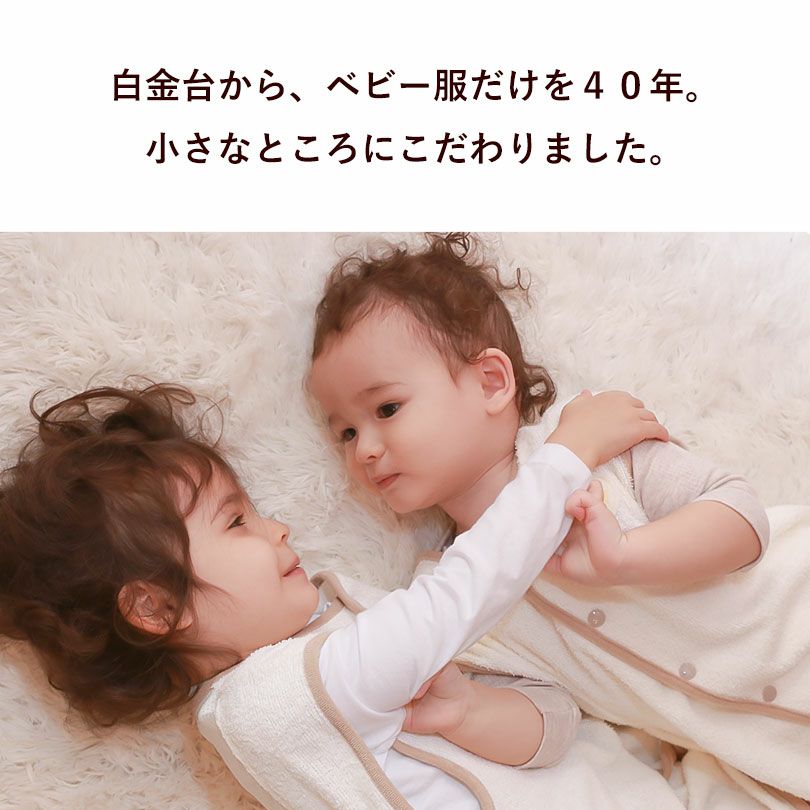 白色のキッズスリーパーを着た2人の幼い子どもが寄り添って寝ている様子