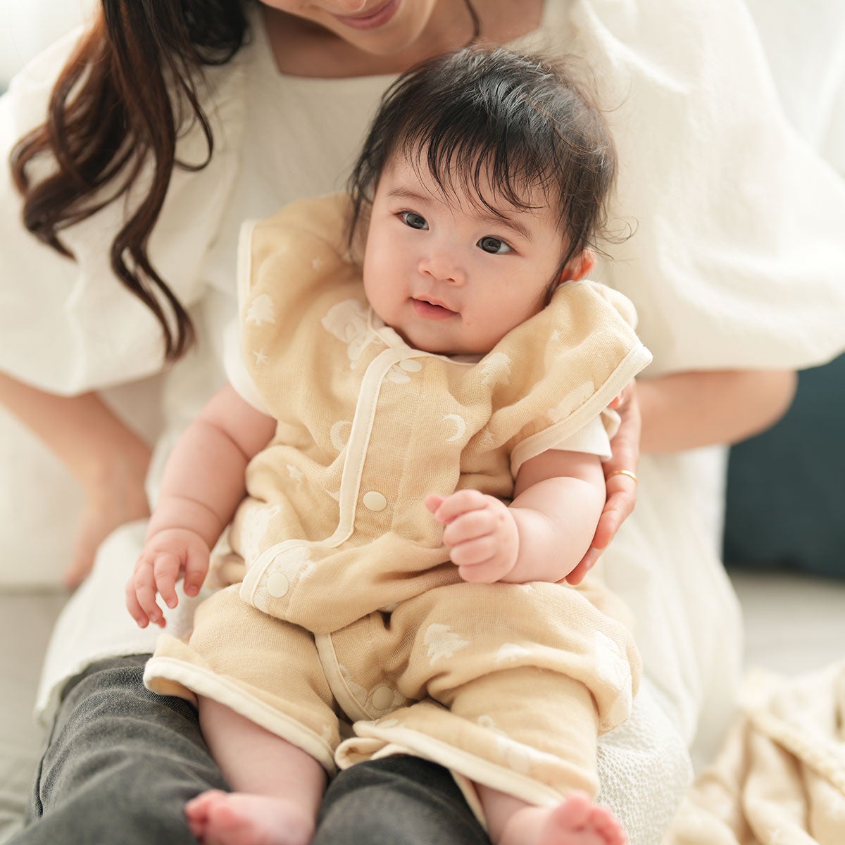ガーゼスリーパーを着た赤ちゃんをママが抱っこしている様子
