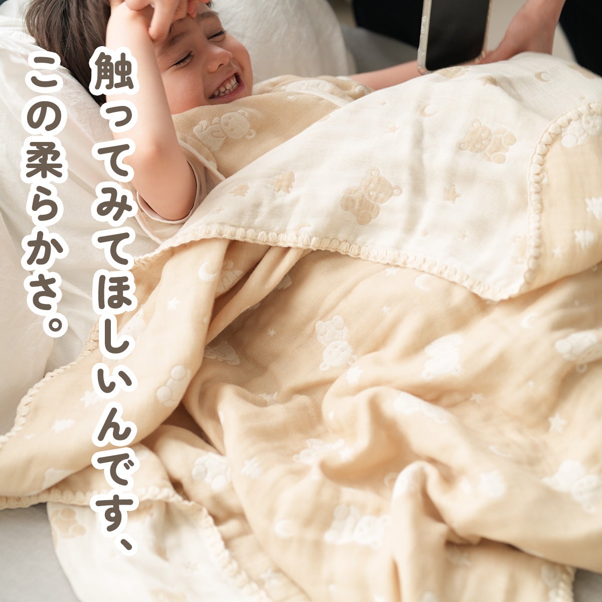 親子でベージュの4重ガーゼケットに包まれてくつろぐ様子